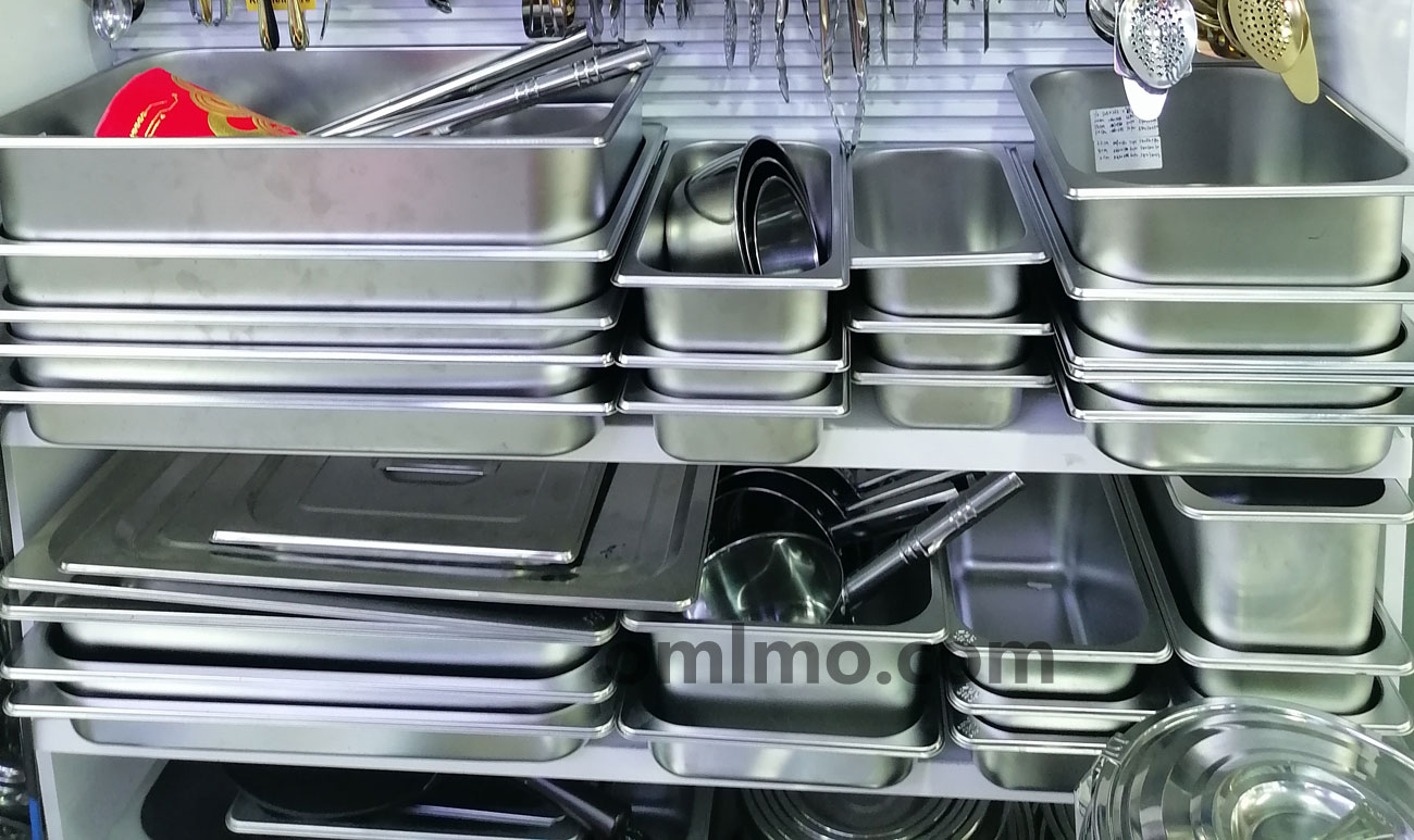 Stainless steel solid and slotted lids for gastronorm pans displayed with matching pans