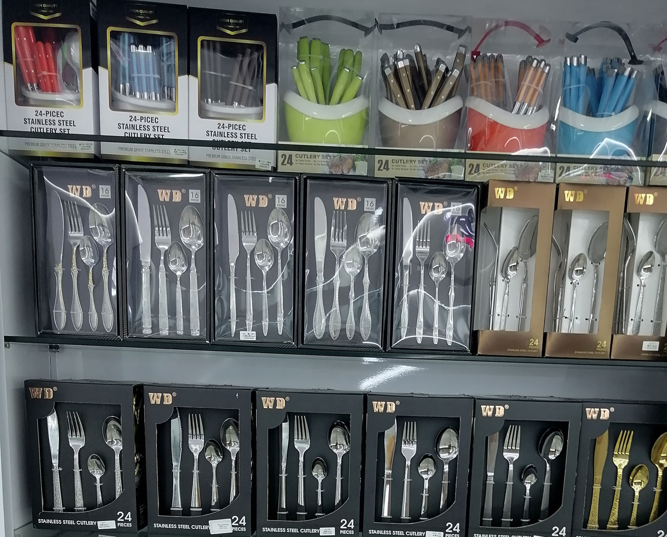 Colored plastic handle 24-piece stainless steel cutlery set series with 8 handle colors on three-tier display shelving