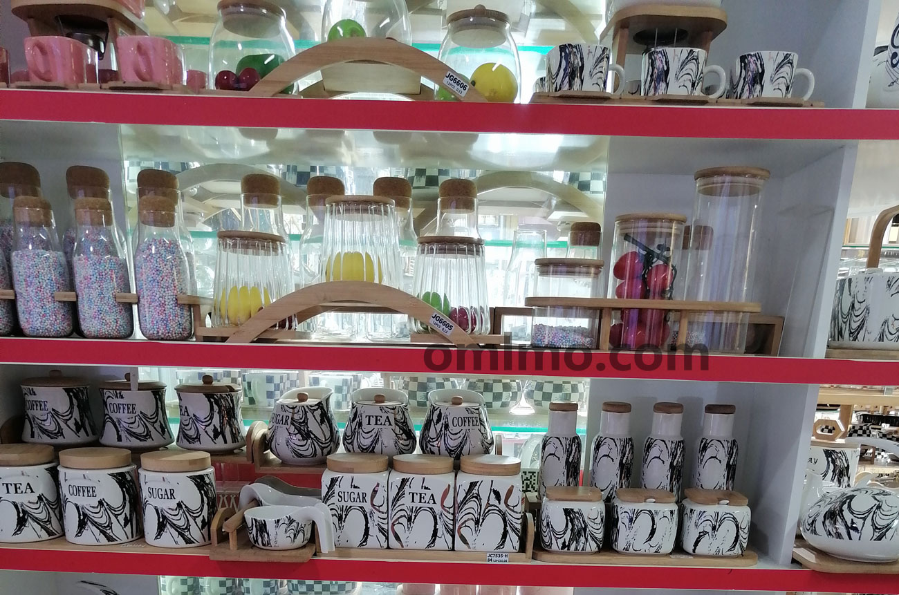 BA-203 Clear glass storage jars with natural wooden lids in multiple sizes displayed on showroom shelf